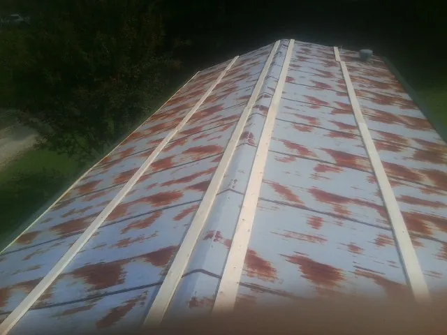Rusted metal roof panels with new wood purlins before replacement — Storm Damage Roof Repair in Surry by Roofing Brothers